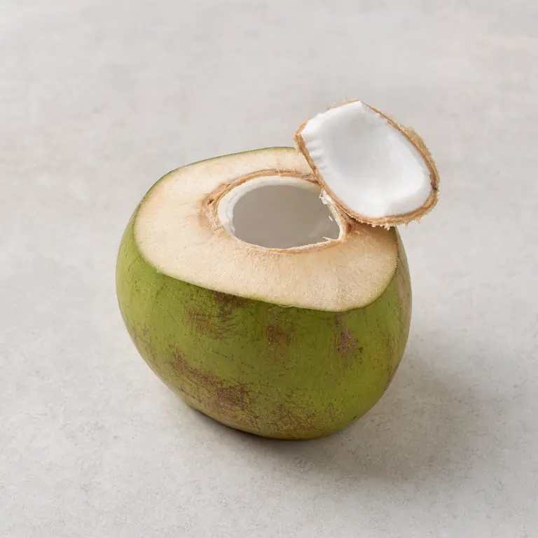 Fresh coconut (cut) on a neutral surface