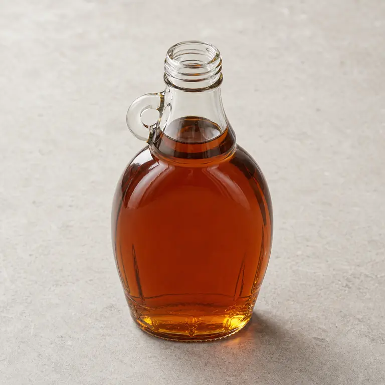 Maple syrup (opened) on a neutral surface